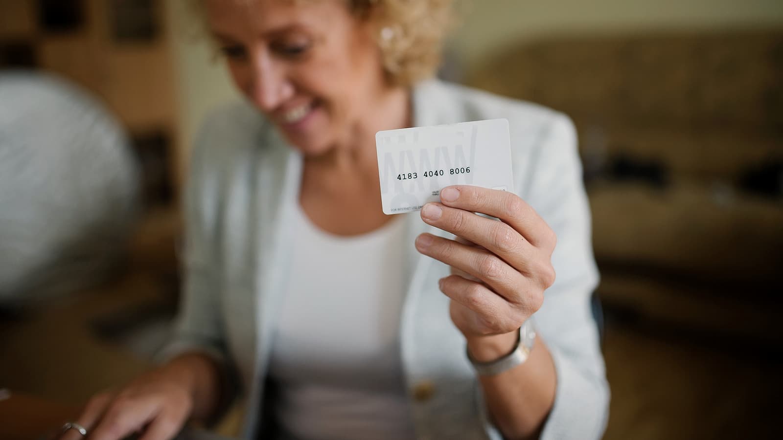 A plastic identification card lying on a dark surface beside a magnifying glass, with small printed fields visible.